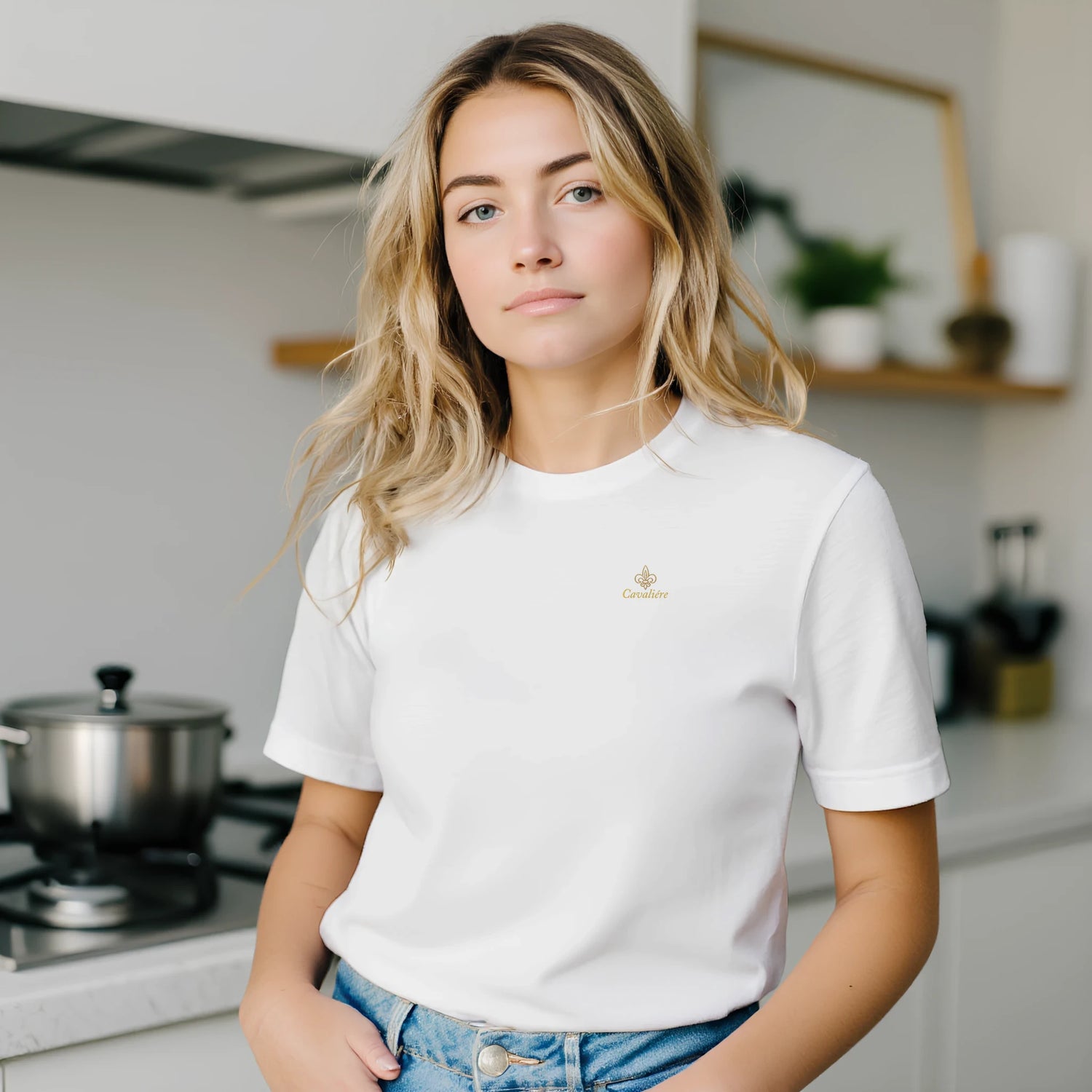 Premium Unisex Crewneck T-shirt | Cavaliére in white with small gold logo, worn casually in modern kitchen setting